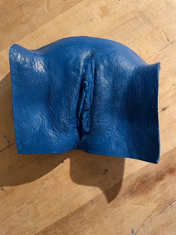 Intimate cast in deep blue pigmented resin on a wooden table