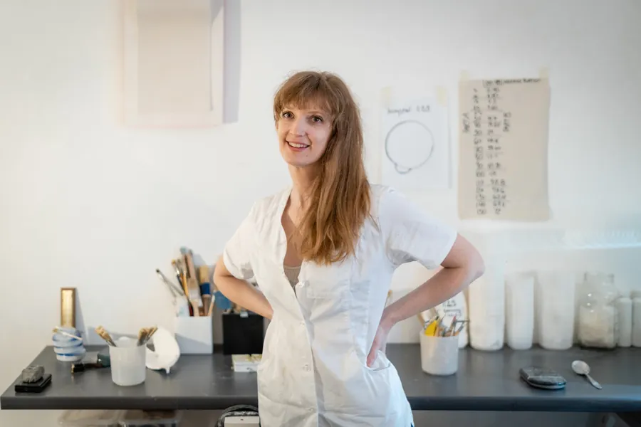 Sculptor Brooke Meenan in her studio in a white work coat