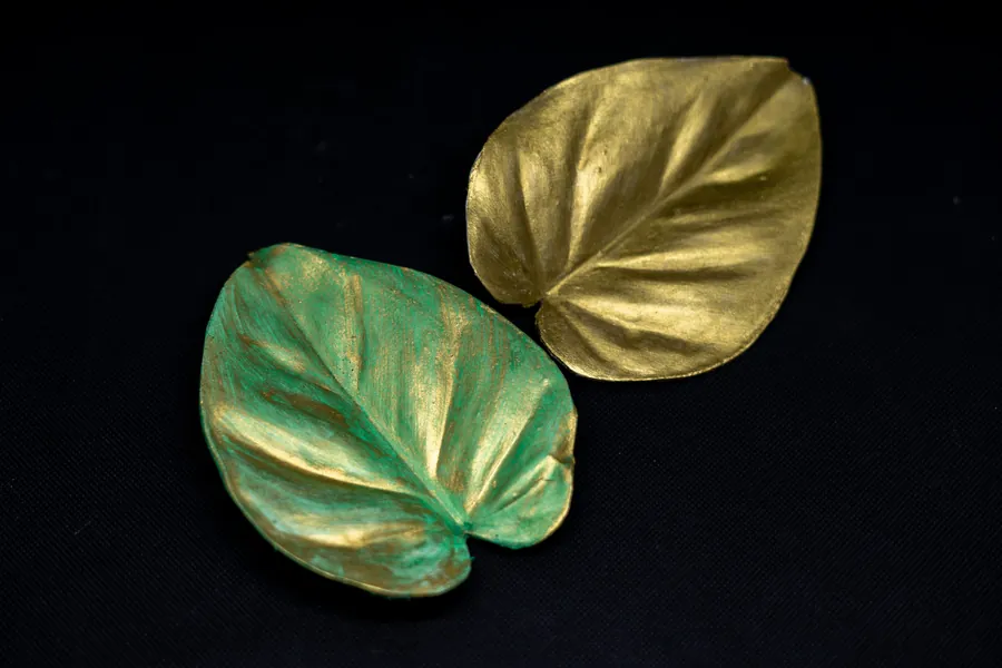 Two cast leaves, one gilded, one green