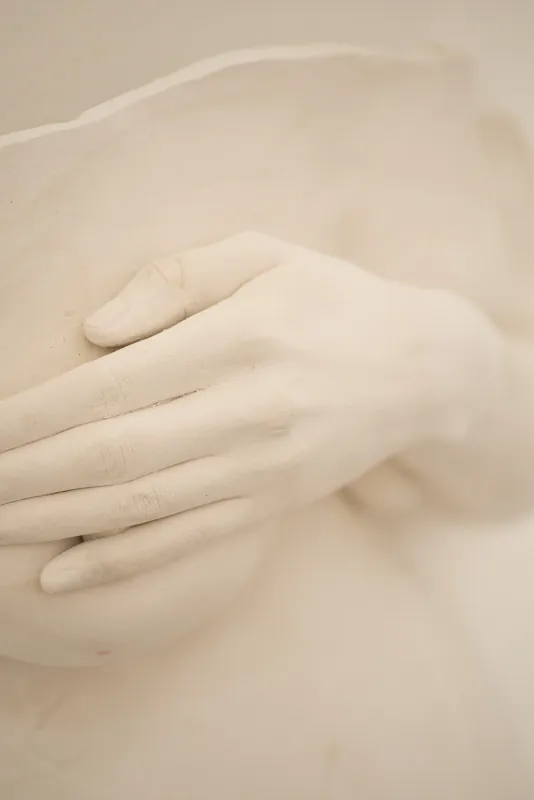 Plaster torso cast with hands, warm light